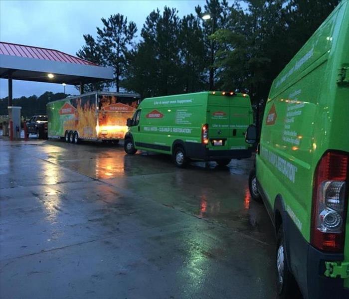 SERVPRO vehicles lined up on wet under a dark, cloudy sky