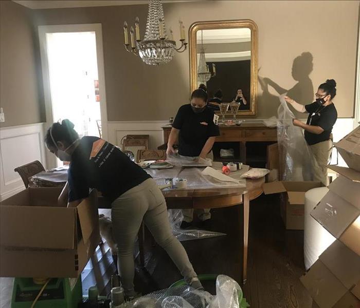 Female SERVPRO employees packing items into boxes