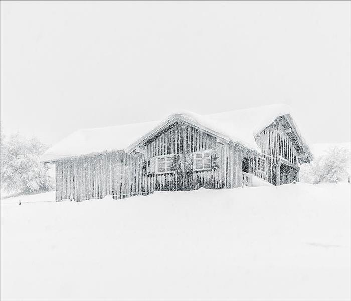House covered in snow and ice in the middle of a snowstorm