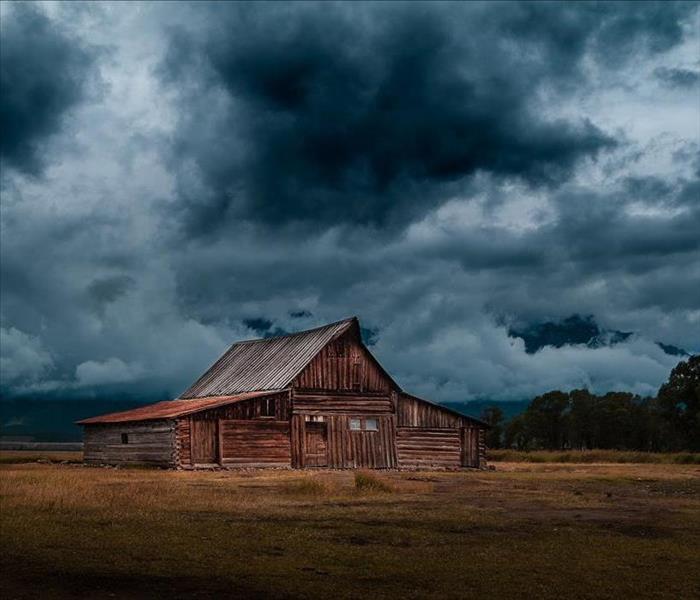 Wooden barn under a dark, stormy sky